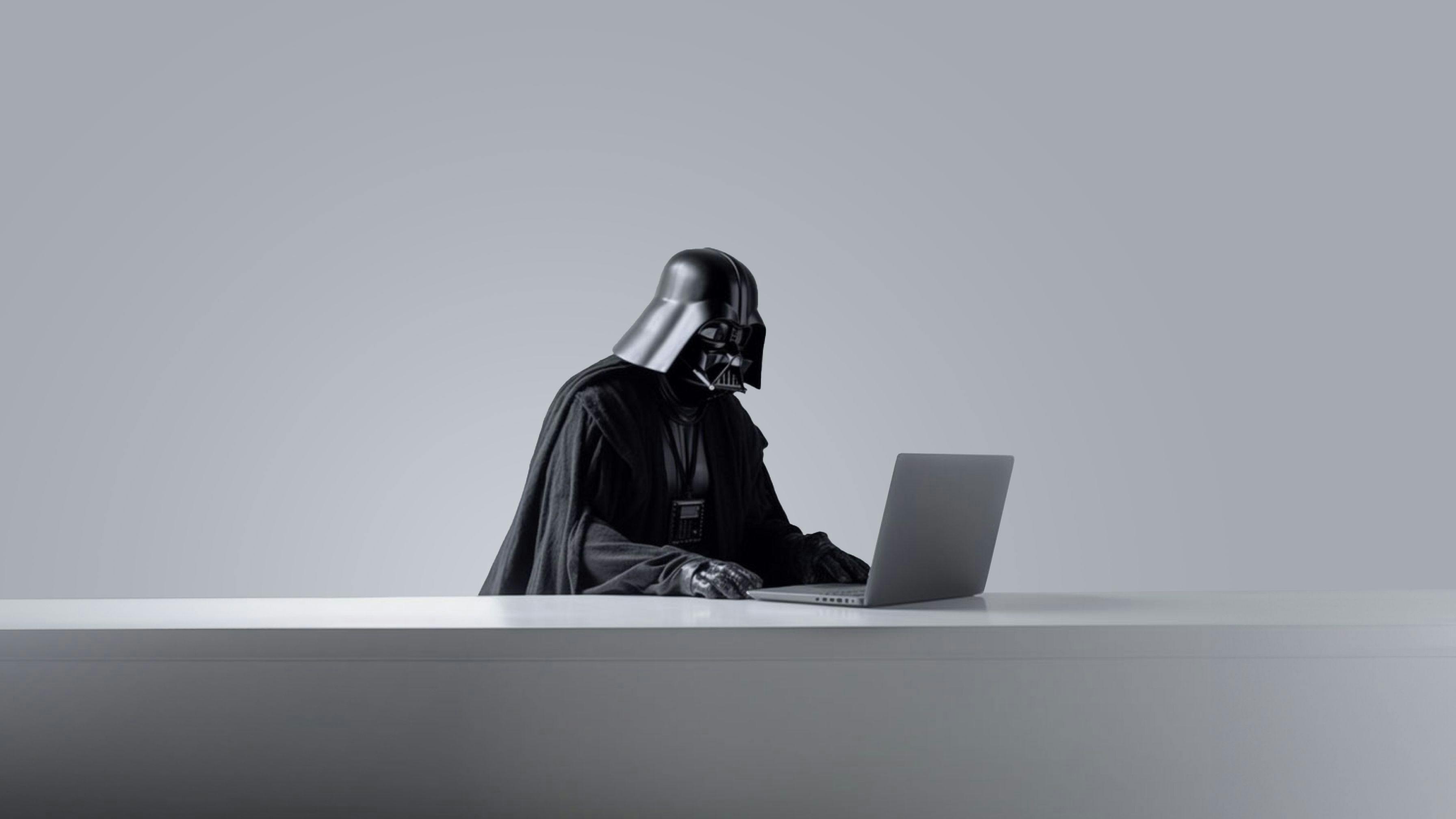 darth vader sitting in front of a macbook